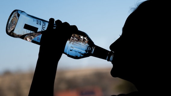 Ein Mädchen trinkt aus einer Flasche Wodka. © Silas Stein/dpa Foto: Silas Stein