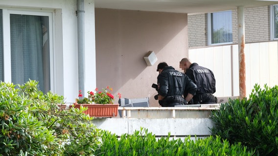 Polizisten durchsuchen einen Balkon im Landkreis Schaumburg. © dpa-Bildfunk Foto: Tobias Landmann/dpa