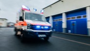 Ein Rettungswagen fährt mit eingeschaltetem Blaulicht über eine Straße. © NDR Foto: Julius Matuschik