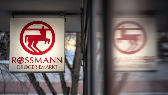 Eine Leuchttafel mit dem Firmenlogo hängt an eine Filiale der Drogeriemarktkette Rossmann in der Mainzer Innenstadt. © dpa Foto: Frank Rumpenhorst