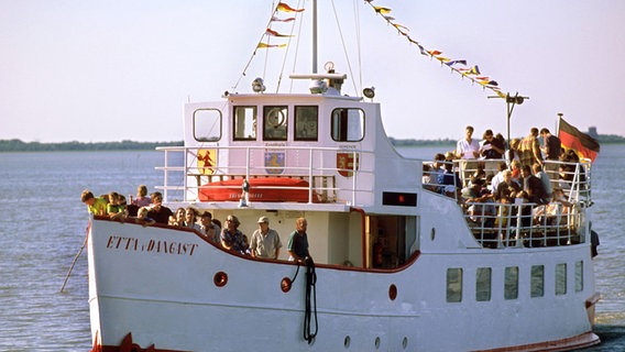 Touristen sind am Deck des Fahrgastschiffs "Edda von Dangast". © picture-alliance/DUMONT Bildarchiv Foto: M.-O. Schulz