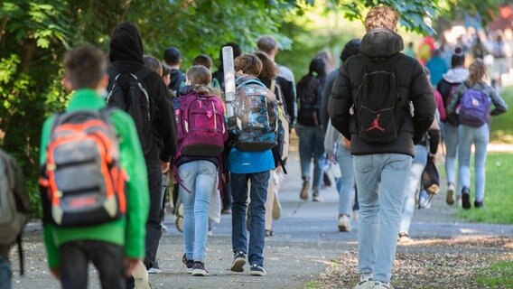 Students walk on a sidewalk.  © dpa-Bildfunk Photo: Julian Stratenschulte