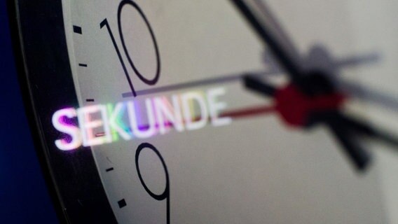 Die Illustration zeigt eine Uhr von Nahem und den Schriftzug "Sekunde". © dpa Foto: Julian Stratenschulte