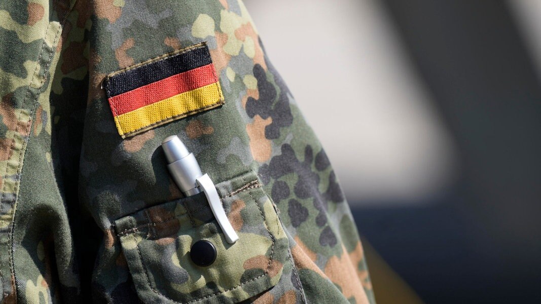 Ein deutsche Flagge ist auf eine Tarnjacke der deutschen Armee genäht.