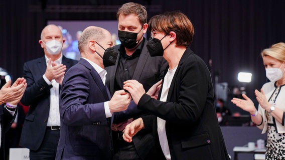 Bundeskanzler Olaf Scholz (SPD, l.) gratuliert Lars Klingbeil (Mitte), neugewählter SPD-Parteivorsitzender, und Saskia Esken, neugewählte SPD-Parteivorsitzende, beim Bundesparteitag ihrer Partei. © dpa Foto: Kay Nietfeld