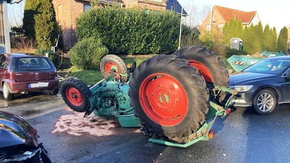 Ein umgestürzter Traktor liegt auf einer Straße. © Polizeiinspektion Stade 