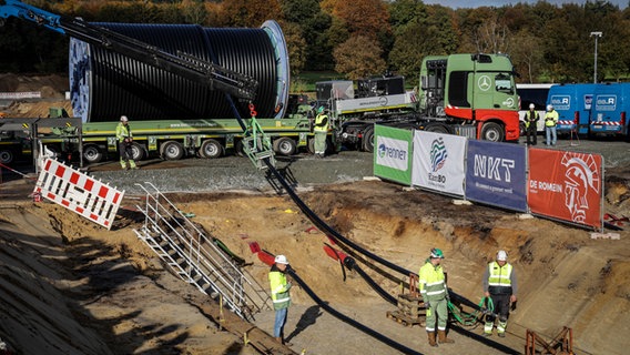 Arbeiter ziehen auf einer Baustelle der SuedLink-Trasse ein Kabel in einen Graben ein. © picture alliance/dpa Foto: Focke Strangmann