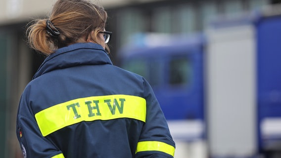 Eine Frau mit einer THW-Jacke steht mit dem Rücken zur Kamera. © picture alliance/dpa | Danny Gohlke Foto: Danny Gohlke