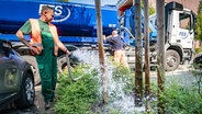 Ein Mitarbeiter der Stadtwerke wässert einen Baum. © picture alliance Foto: Frank Rumpenhorst