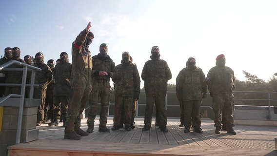 Ukrainische Soldaten werden von einem Bundeswehrsoldaten auf einer Schießbahn eingewiesen. © NDR 