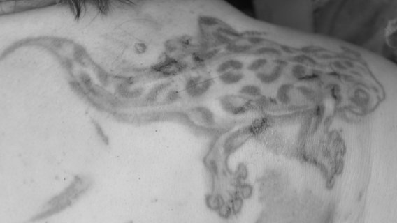 Ein Echsen-Tattoo auf dem rechten Schulterblatt einer Frau. © Polizei Peine 
