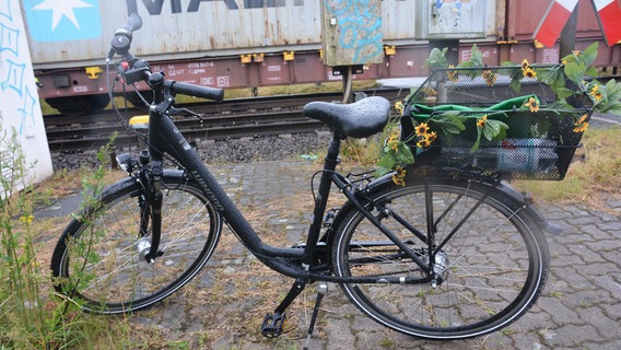 Schwarzes Fahrrad mit Blumenkette um den Fahrradkorb. © Polizei Peine 