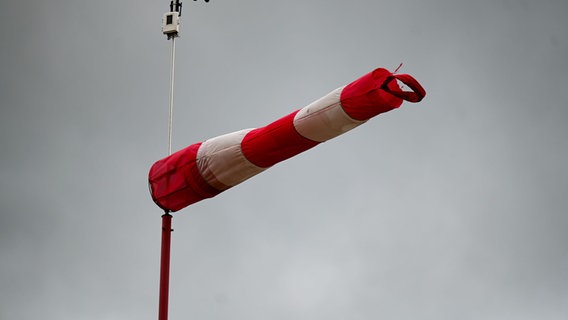 Ein Windsack in starkem Wind vor grauem Himmel (Themenbild Unwetter). © picture alliance/dpa Foto: Marius Bulling