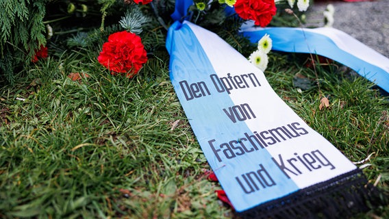 Ein Blumenkranz mit einem Band mit dem Aufdruck "Den Opfern von Faschismus und Krieg" liegt am Mahnmal für die Opfer des Konzentrationslagers Ahlem. © picture alliance/dpa/Michael Matthey Foto: Michael Matthey