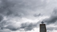 Dunkle Wolken ziehen über das Markenhochhaus auf dem Gelände vom VW Werk Wolfsburg hinweg. © picture alliance/dpa Foto: Julian Stratenschulte