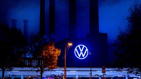 Blick auf das in blaues Licht getauchte VW-Logo am Stammsitz in Wolfsburg © picture alliance / Kirchner-Media Foto: David Inderlied