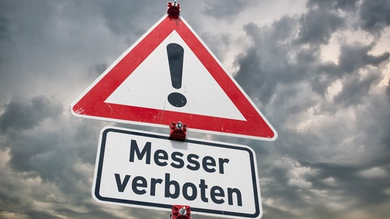 Warnschild "Gefahrstelle" und ein Zusatzschild mit der Aufschrift "Messer verboten" vor bewölktem Hintergrund. © picture alliance / SULUPRESS.DE | Torsten Sukrow / SULUPRESS.DE Foto: Torsten Sukrow