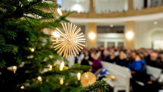 Ein Strohstern hängt während eines Gottesdienstes in der Oldenburger Lambertikirche an einem Weihnachtsbaum. © dpa-Bildfunk Foto: Hauke-Christian Dittrich