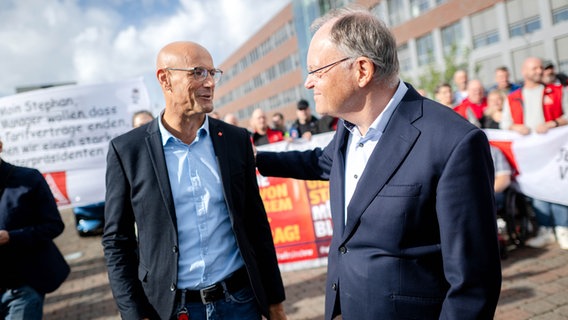 Ministerpräsident Stephan Weil (SPD) ist im Gespräch mit Herbert de Vries, stellvertretender Betriebsratsvorsitzender bei VW in Emden. © picture alliance/dpa Foto: Sina Schuldt