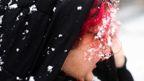 Schneeflocken hängen in den Haaren einer Person in Hannover. © dpa Foto: Julian Stratenschulte