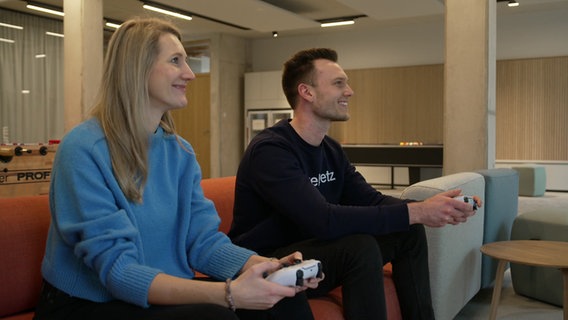 Leonie Braunert und Jannis Reske sind Mitarbeitende der Lüneburger Firma "webnetz" und spielen Playstation auf der Arbeit. © NDR 