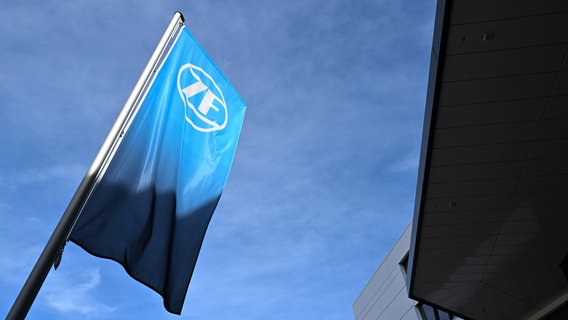 Eine Fahne mit dem Logo des Automobilzulieferers ZF weht am 16. März 2023  vor der Konzernzentrale, dem ZF-Forum. © picture alliance / dpa | Felix Kästle Foto: Felix Kästle