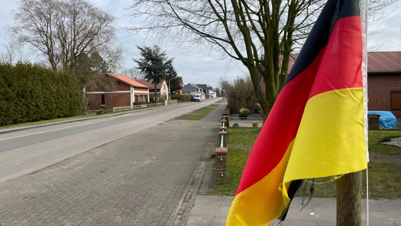 An der Hauptstraße von Averlak weht eine Deutschland-Fahne. © NDR Foto: Bastian Pöhls