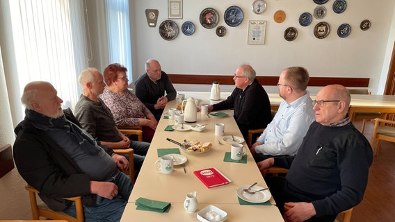 In der Begegnungsstätte von Averlak sitzen mehrere Personen um einen Tisch. © NDR Foto: Bastian Pöhls