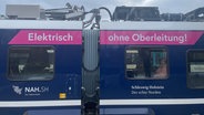 Auf der Seite eines Zuges steht: "Elektrisch - Ohne Oberleitung!" © NDR Foto: Onno Eick