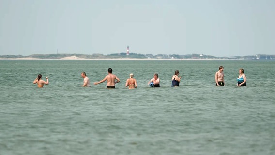 Menschen stehen im Wasser am Strand auf Amrum. © NDR 