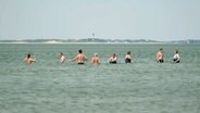 Menschen stehen im Wasser am Strand auf Amrum. © NDR 