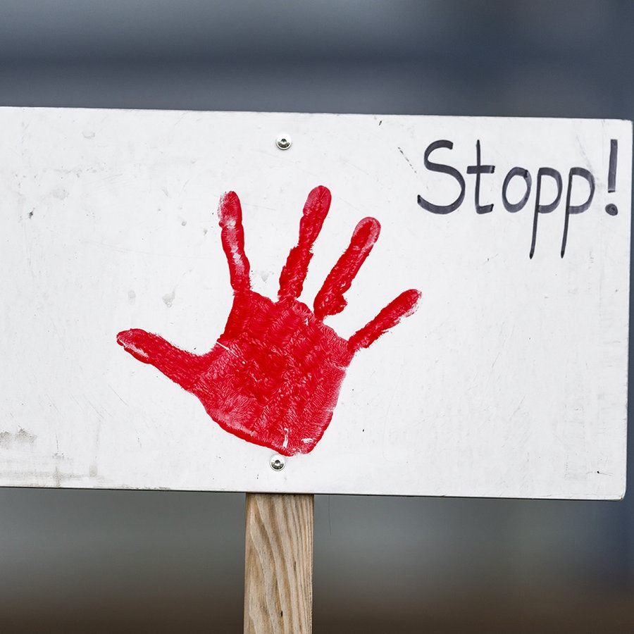 Auf einem weißen Schild ist ein roter Handabdruck sowie der Schriftzug "Stopp!". © picture alliance Foto: Zoonar | HJ Janda