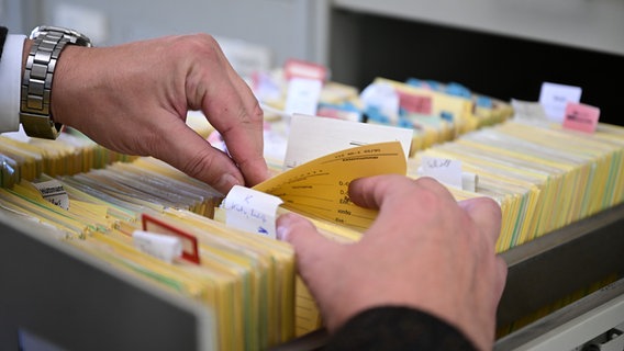 Jemand sucht nach etwas in einem Karteischrank. © picture alliance/dpa Foto: Bernd Weißbrod