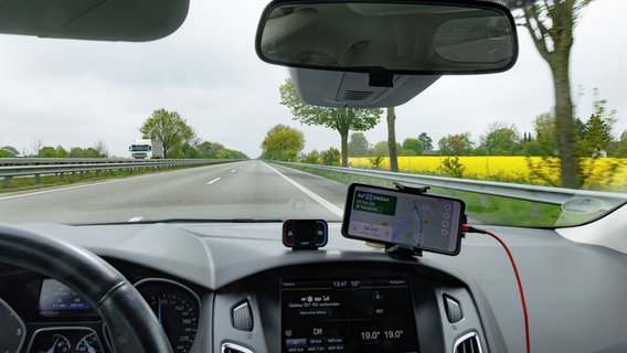 Blick während der Fahrt durch die Windschutzscheibe eines PKW auf die Autobahn A21. © picture alliance Foto: Markus Scholz