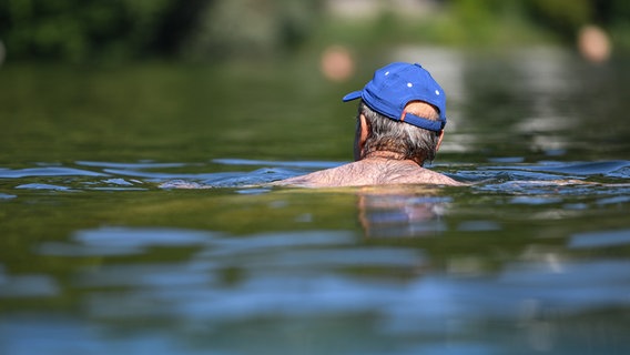 Ein Mann mit blauer Cap schwimmt in einem See. © picture alliance/dpa | Felix Kästle Foto: Felix Kästle