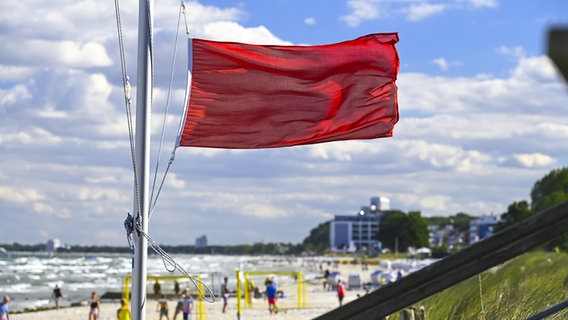 Eine rote Flagge weht am Ostseestrand von Scharbeutz in Schleswig-Holstein. © Picture Alliance Foto: Christian Ohde