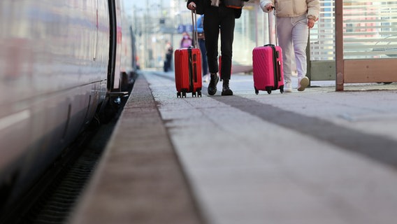 Zwei Frauen mit Koffer gehen am Bahngleis entlang © NDR Foto: Pavel Stoyan