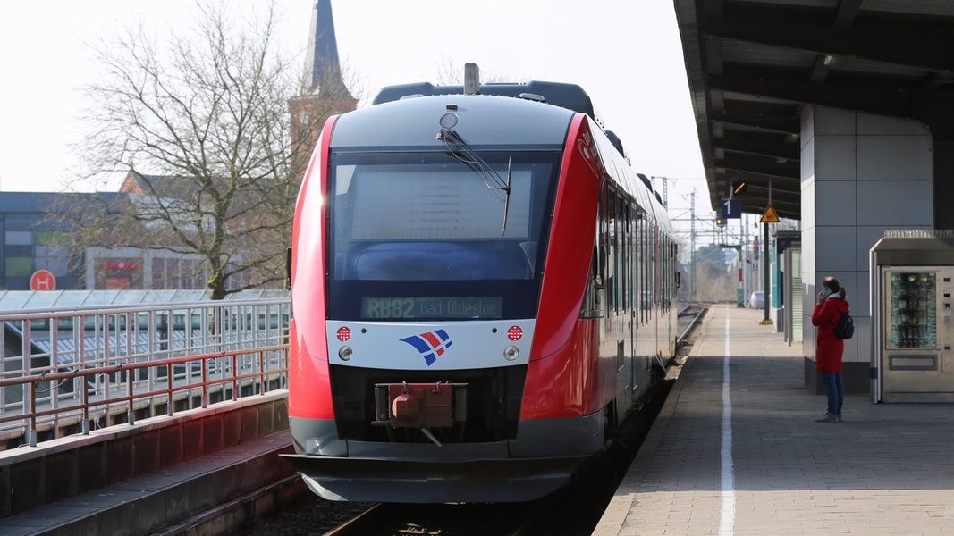 Ein roter Zug der nordbahn nach Bad Oldesloe steht an einem Bahnsteig in Neumünster.