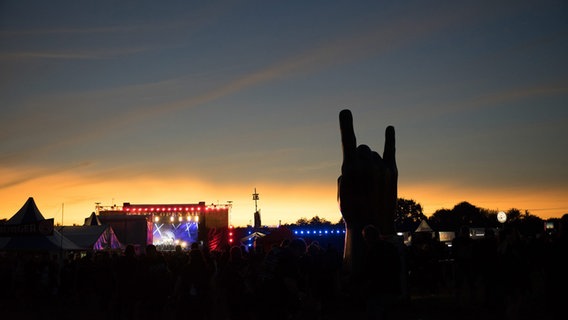 Eine Metalhand auf einem Open Air Konzert bei Sonnenuntergang © picture alliance / rtn - radio tele nord Foto: Frank Dudek