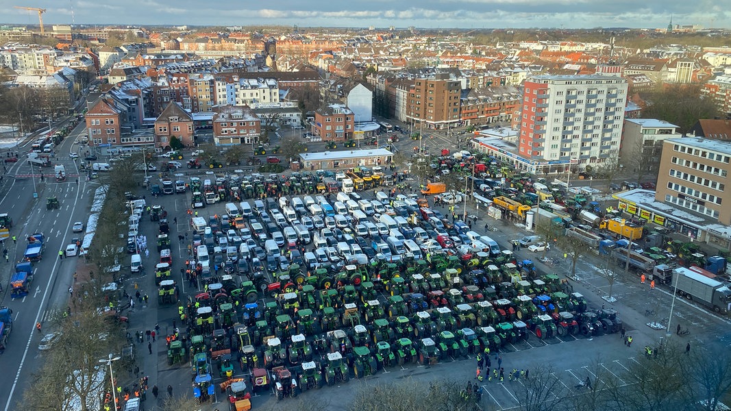 Auf dem Exerzierplatz in Kiel sammeln sich Traktoren und Transportwagen.