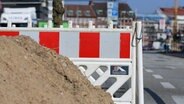 Absperrzaun und ein Haufen Sand stehen am Straßenrand. © NDR Foto: Pavel Stoyan