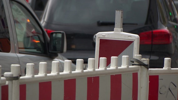 Hinter der Absperrung einer Baustelle fahren Autos. © NDR 