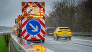 Warnhinweis Spurwechsel an einem Fahrzeug der Autobahnmeisterei auf der Autobahn A4 bei Regen © picture alliance / imageBROKER Foto: Matthias Graben