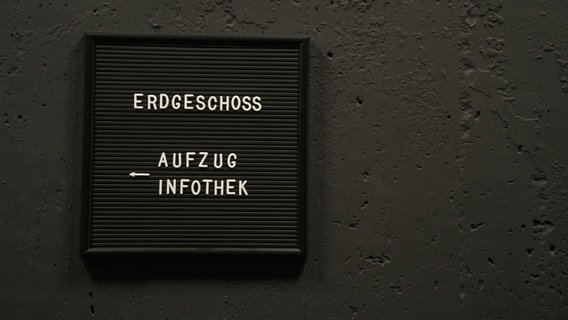 Ein Hinweisschild mit der Aufschrift: Erdgeschoss Aufzug Infothek © NDR Foto: NDR Screenshot