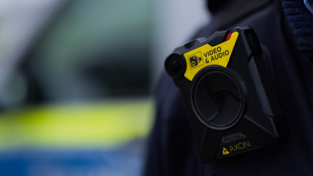 Eine Bodycam für Audio- und Videoaufnahme steckt an einer Uniform einer Polizistin.