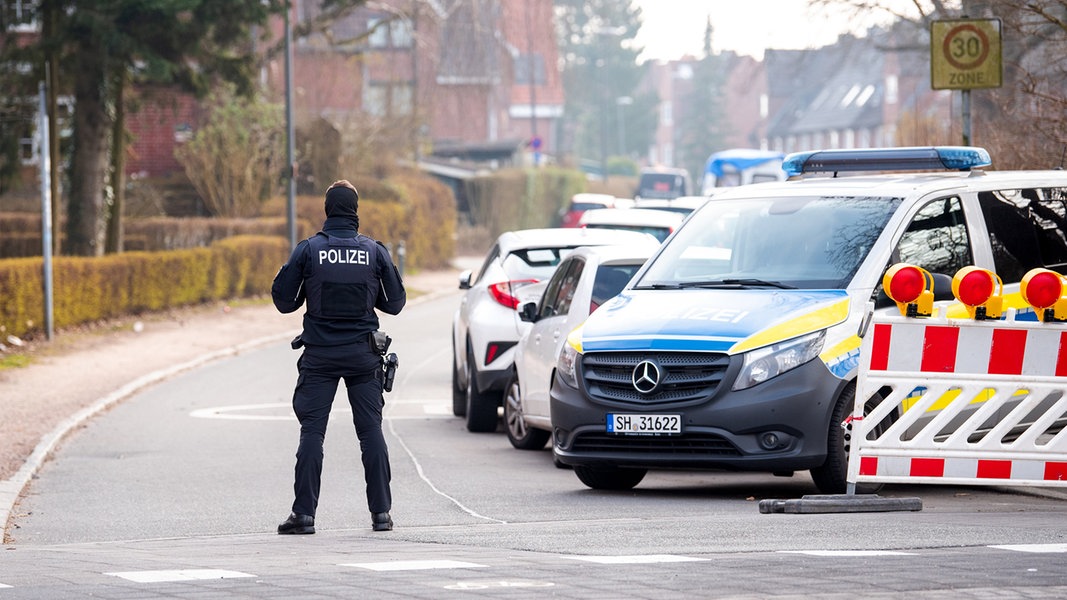 Kiel: Ein Polizist sperrt im Stadtteil Elmschenhagen die Zufahrt zu einem Wohngebiet ab. Wegen der Entschärfung von vier Fliegerbomben aus dem Zweiten Weltkrieg.