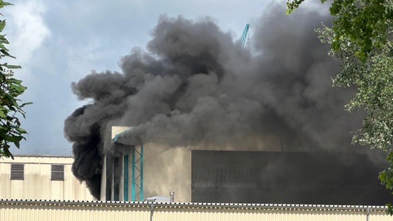 Dunkle Rauchschwaden steigen aus einer Halle der Werft auf. © Daniel Friederichs Foto: Daniel Friederichs