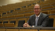 Helge Braun sitzt in einem Hörsaal. © NDR 