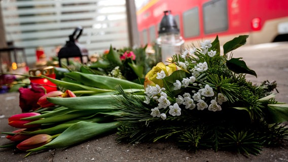Des bougies et des fleurs se tiennent ou se trouvent dans un abribus à la gare de Brokstedt.  Deux jeunes ont été tués et d'autres blessés lors d'une attaque au couteau contre un train régional de Kiel à Hambourg le 25 janvier 2023 à Brokstedt.  © picture alliance/dpa Photo : Daniel Bockwoldt