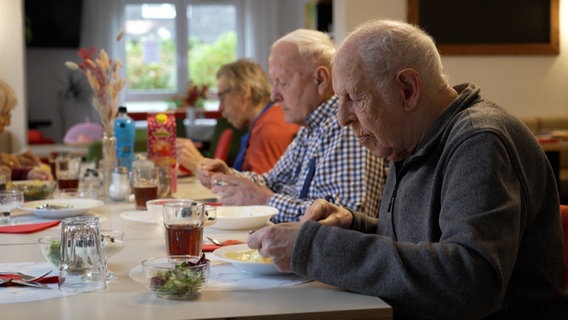 Einige ältere Menschen sitzen bei einem gemeinsamen Abendessen an einem Tisch © NDR Foto: NDR Screenshot